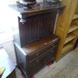 A 1920s oak cupboard, with 2 linenfold panelled cupboard doors above drawers and cupboards, on