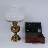 A Vintage lithographed tin Maison Lyons Toffee briefcase box, and a brass oil lamp with milk glass