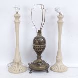A Middle Eastern brass and black enamel table lamp, and a pair of cream painted wood table lamps,