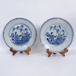 A pair of Chinese porcelain plates, 23.5cm, on wooden stands