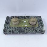 A large polished green marble desk stand, with double brass inkwells and inset central onyx panel,