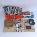 A collection of various topographical postcards and cigarette cards
