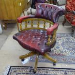 A reproduction studded leather-upholstered revolving desk chair