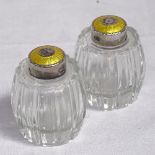 A pair of glass barrel design pepperettes with silver and yellow enamel mounts, by Hugo Grun,
