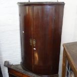 A 19th century mahogany bow-front 2-door hanging corner cupboard, H90cm