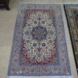 A cream ground Persian design rug with a symmetrical pattern, 160cm x 108cm