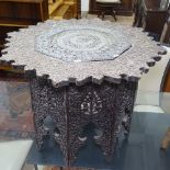 An Indian carved and pierced hardwood occasional table, with an inset and pierced copper panel on