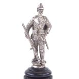 An unmarked white metal Russian soldier figure, on turned wood column, figure height 59mm, overall