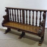 A 19th century carved oak hall settle with spindle-back and lion paw feet, length 158cm