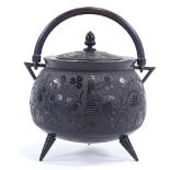 A large Irish bog-oak caldron design pot and cover, with swing handle and allover relief carved