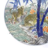 A large Japanese Meiji period porcelain charger, with enamel decoration of tigers' in flood, blue
