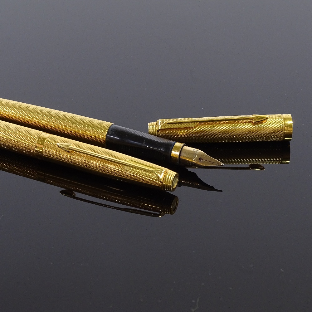 2 Parker fountain pens, engine turned gilt metal cases with 14ct gold nibs, overall length 13cm, (2)