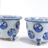 A pair of Japanese Meiji period blue and white porcelain jardinieres, with relief flower panels
