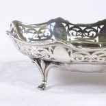 A George V oval silver bon bon dish, scalloped and pierced frieze with 4 scrolled feet, by Colen