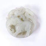 A Chinese relief carved and pierced jade elephant design pendant, 5cm across