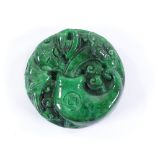 A Chinese relief carved jade circular pendant, 4.5cm across