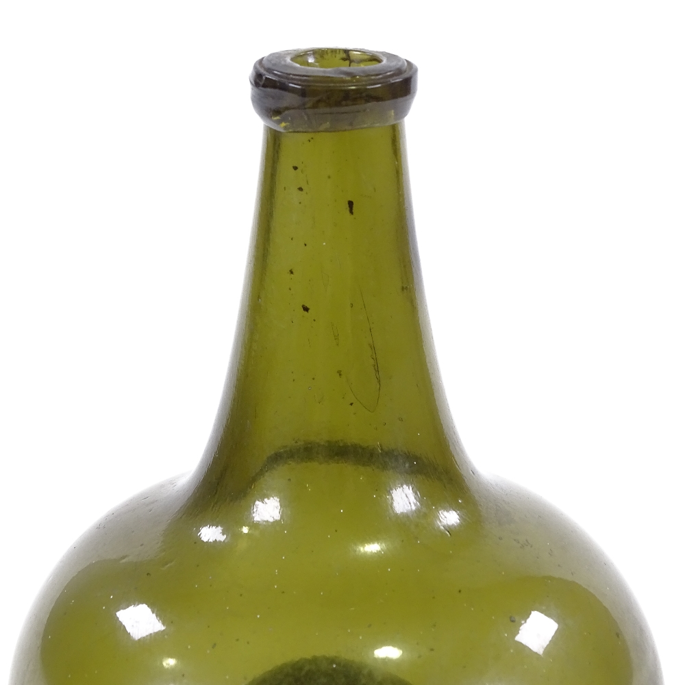 An 18th century handmade green glass onion-shaped bottle, height 17cm