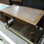 A Victorian Carolean style oak library writing table, with frieze drawers, inset leather top on