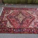 A Caucasian handmade red and blue ground geometric design rug, 265cm x 188cm