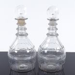 A pair of Georgian glass decanters, with bulls-eye stoppers, fluted and prism cut decoration, height