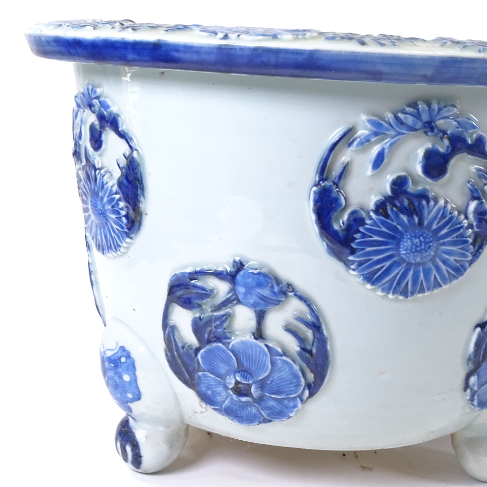 A pair of Japanese Meiji period blue and white porcelain jardinieres, with relief flower panels - Image 5 of 13