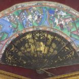 A Chinese painted fan in frame, with lacquered staves and faces of figures made from inlaid ivory,