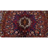 A large handmade Caucasian red and blue ground geometric design rug, 4.45m x 3.33m (14'7" x 10'