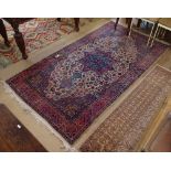 An Antique red ground Shiraz design rug, with symmetrical border and pattern, 240cm x 135cm
