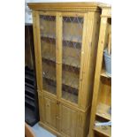 A polished pine floor standing bookcase, with leadlight glazed and panelled doors, W84cm, H200cm