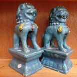 A pair of blue glazed terracotta Dogs of Fo on plinths, height 25cm