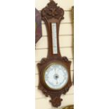 An oak-cased wall hanging wheel barometer and thermometer, case height 88cm