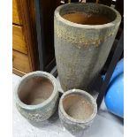 A graduated set of textured terracotta garden planters, tallest 71cm