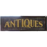 A contemporary black and gold painted rectangular Antiques shop sign, with ebonised frame, overall
