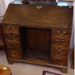 A Georgian oak bureau, with fall-front, recessed cupboard flanked by 4 short drawers, bracket