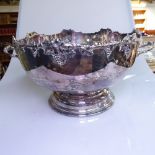 A large silver plate on copper 2-handled punch bowl, with cast grape and vine-shaped edge on