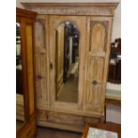 A 1920s carved and panelled oak single mirror-door wardrobe, with drawer fitted base, W130cm