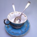 An Edwardian Staffordshire coffee cup and saucer, in a stylised scrolled and pierced silver stand,