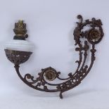 A wrought-iron wall-mounted milk glass oil lamp, bracket length 50cm