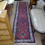 A red ground Beluchi style runner, with symmetrical pattern and border, 3332cm x 83cm