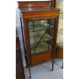 An Edwardian mahogany narrow display cabinet, with lattice glazed door, raised on square tapered