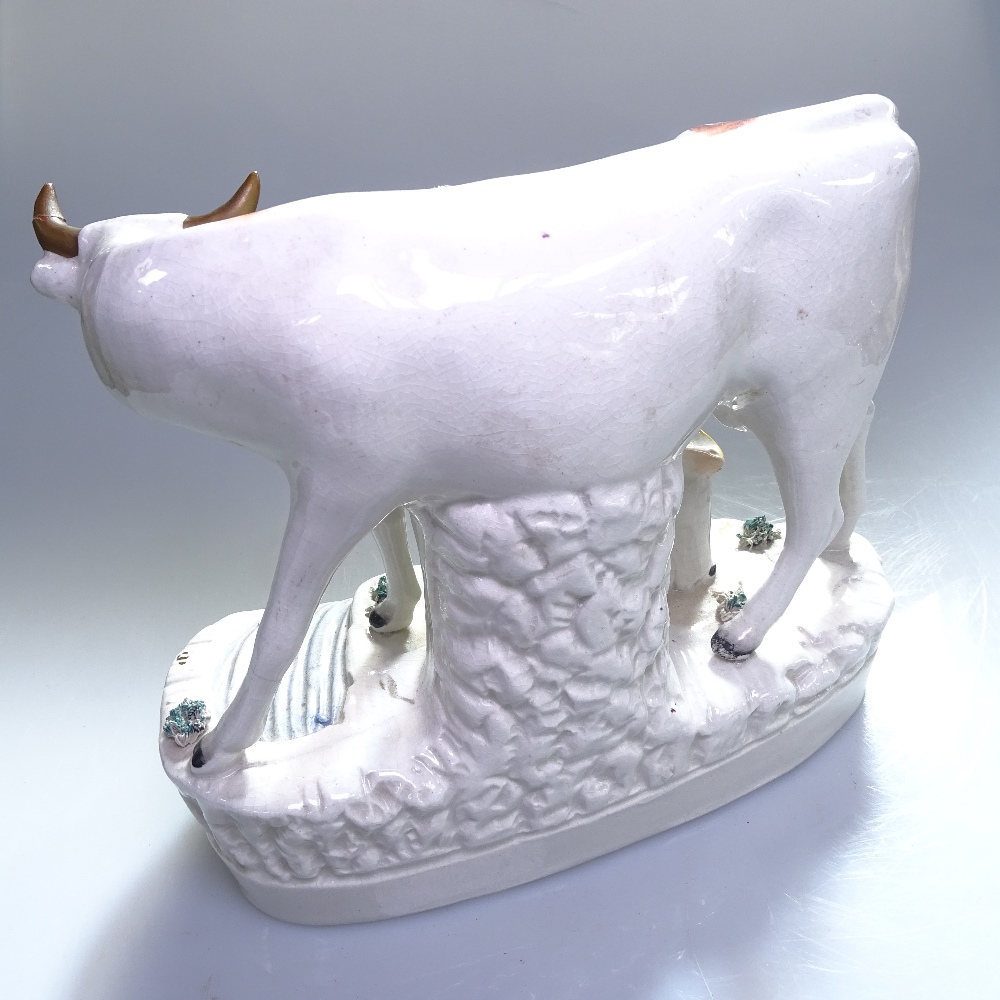 An early Staffordshire figure of a cow with milkmaid, on plinth, height 16cm - Image 2 of 2