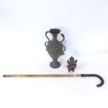 A small Buddhist bronze deity sculpture, a heavily engraved brass 2-handled urn, and a leather-