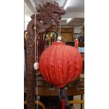 A Chinese relief carved standard lamp in the form of a dragon, with needlework decorated balloon