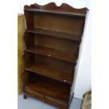 A mahogany waterfall open bookcase with drawers to the base, on bracket feet, W76cm