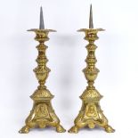 A pair of cast-brass pricket candlesticks, relief embossed religious portraits and scenes, overall