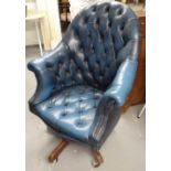 A button-back blue leather-upholstered swivel armchair