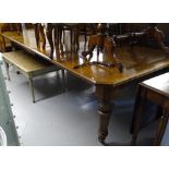 A 19th century oak wind-out dining table, having carved frieze raised on carved tapered legs, with 3