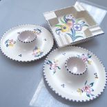 Poole Pottery plates with painted floral and bird decoration, egg cups, and an ashtray