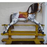 A speckled grey painted wooden rocking horse, on original painted pine stand, L137cm, H122cm