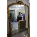 An Antique carved gilt-framed and gesso arch-top over mantel mirror, with acanthus leaf pediment,